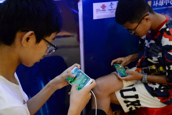 Hai thiếu niên đang chơi game Vương giả vinh diệu do Tencent phát hành (Ảnh: Nguồn quốc tế)