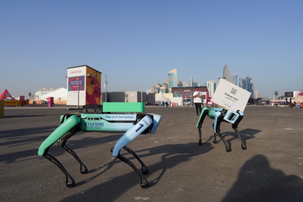 Chó robot mang biển chào mừng di chuyển khắp nơi trong khu vực sự kiện. 